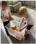 Two children with pumpkins in a water tub