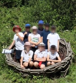 Children sitting in a giant woven nest
